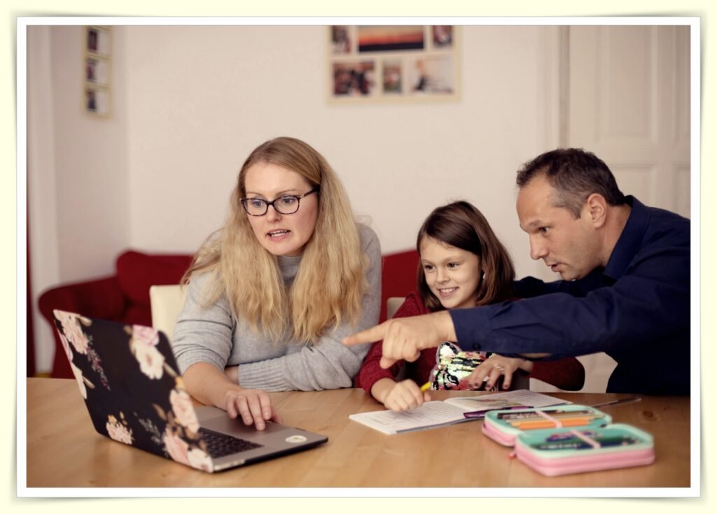 family sitting together reviewing budget on laptop