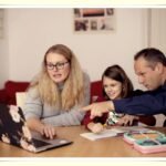 family sitting together reviewing budget on laptop