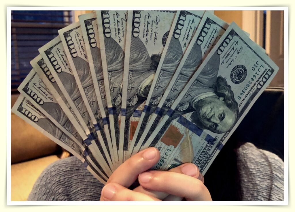 person carefully counting cash on tight minimum wage budget