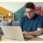 person reviewing monthly bills on laptop at home to cut expenses