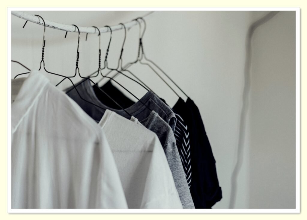 minimal capsule wardrobe hanging in closet to save money on clothes